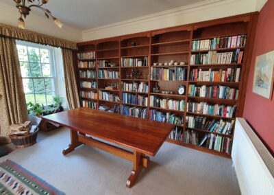 Bespoke solid oak refectory table stained to match bookcase